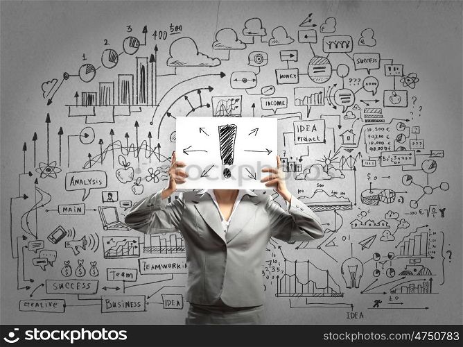 Business ideas. Businesswoman hiding her face with sheet of paper with sketches at background