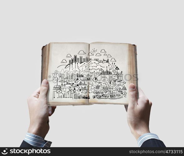 Business ideas. Close up of businessman hands holding opened book with sketches