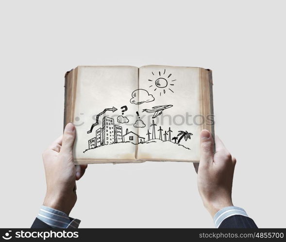 Business ideas. Close up of businessman hands holding opened book with sketches