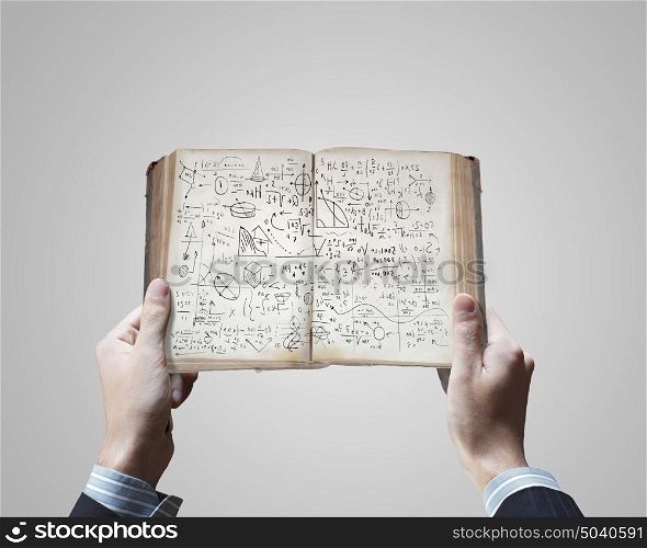 Business ideas. Close up of businessman hands holding opened book with sketches