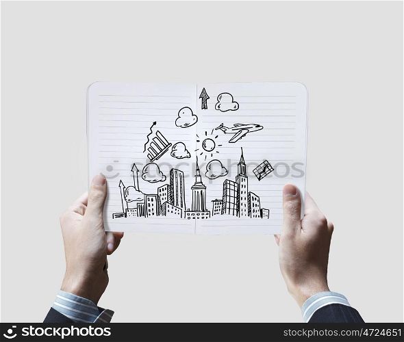 Business ideas. Close up of businessman hands holding opened notepad with sketches