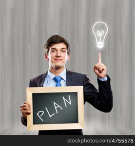 Business ideas. Handsome businessman holding wooden frame with words