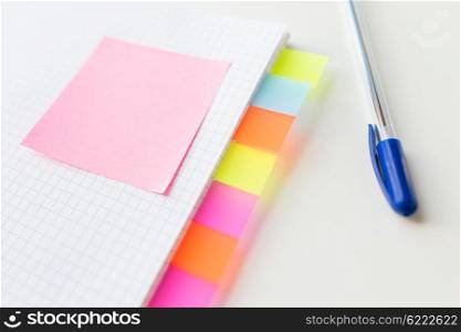 business, information, memo, management and education concept - close up of notebook or organizer with blank tags and sticker and pen on office table