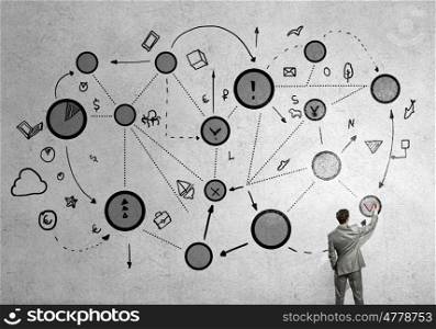 Business interaction. Back view of businessman drawing connection lines on wall