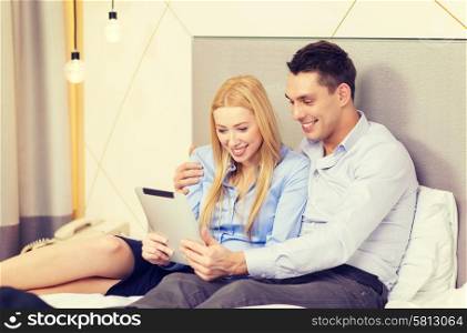 business, internet and technology concept - couple with tablet pc computer in hotel room