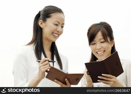Business ladies checking schedule each other