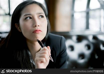 Business lady pondering over ideas for new business project, Portrait of a beautiful young woman thinking