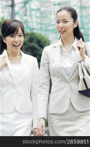Business lady walking with fellow worker