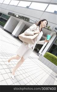 Business lady walking with having a cup
