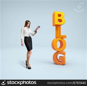 Business lady with tablet pc stands near word blog. Idea concept.