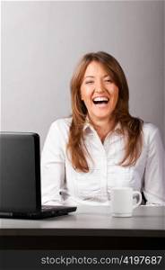 business laughing woman is sitting in the office with laptop