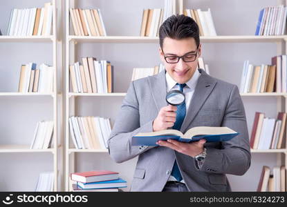 Business law student with magnifying glass reading a book. Businessman student reading a book studying in library