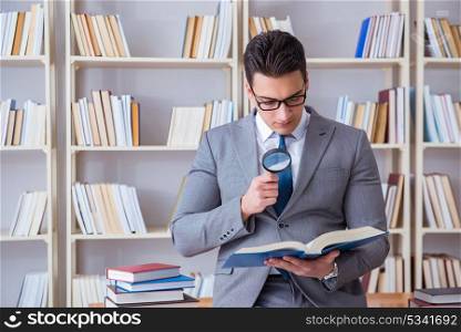 Business law student with magnifying glass reading a book. Businessman student reading a book studying in library