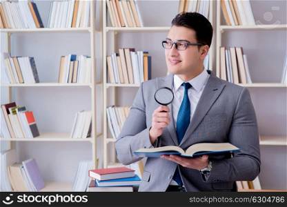 Business law student with magnifying glass reading a book. Businessman student reading a book studying in library