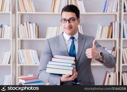 Business law student with pile of books working in library