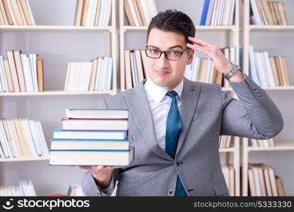 Business law student with pile of books working in library