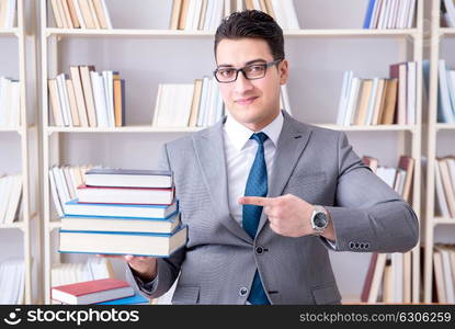 Business law student with pile of books working in library