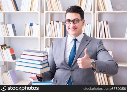 Business law student with pile of books working in library