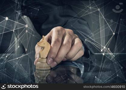 Business leadership strategy. Close up of man hand making chess move on dark background