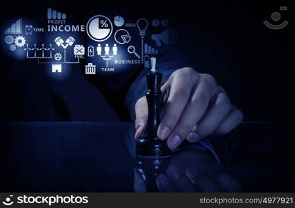 Business leadership strategy. Close up of man hand making chess move on dark background