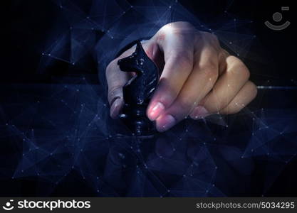 Business leadership strategy. Close up of man hand making chess move on dark background