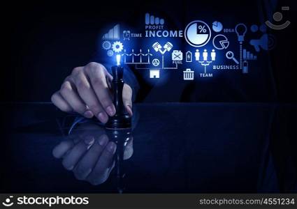 Business leadership strategy. Hand of businessman on dark background making chess move