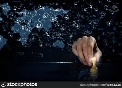 Business leadership strategy. Hand of businessman on dark background making chess move