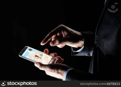 business, location, people and future technology concept - close up of businessman hands with transparent smartphone with gps navigator map on screen over black background. close up of businessman with gps map on smartphone