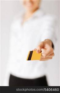 business, luxury, shopping and money concept - woman showing gold credit card