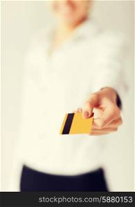 business, luxury, shopping and money concept - woman showing gold credit card