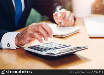 Business man accounting using calculating and work with laptop computer on desk office, finance concept