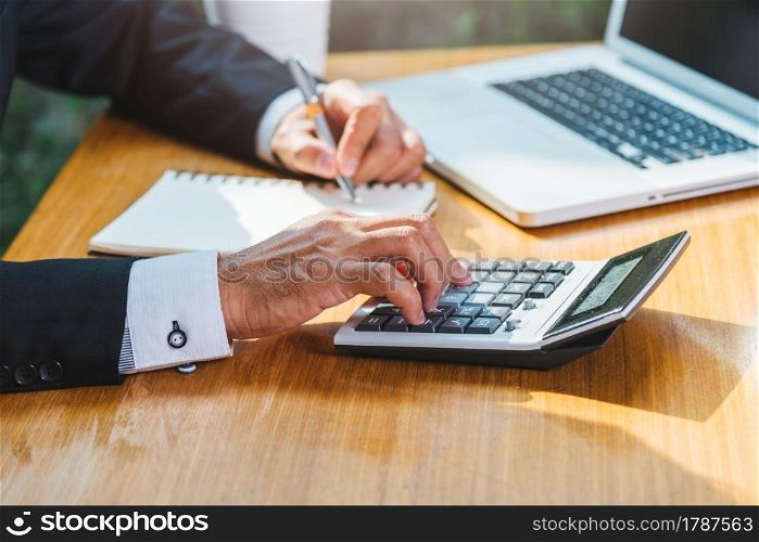 Business man accounting using calculating and work with laptop computer on desk office, finance concept