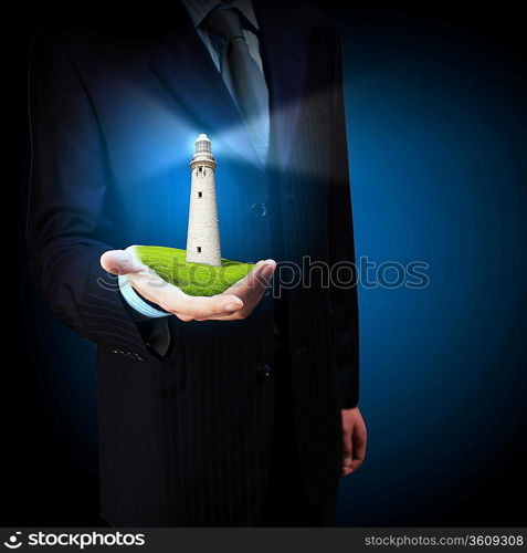 Business man and a lighthouse shining in darkness