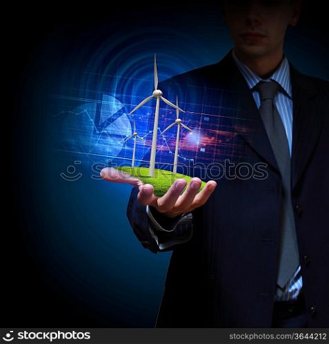 Business man and a windmills as a symbol of green energy