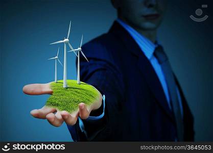Business man and a windmills as a symbol of green energy