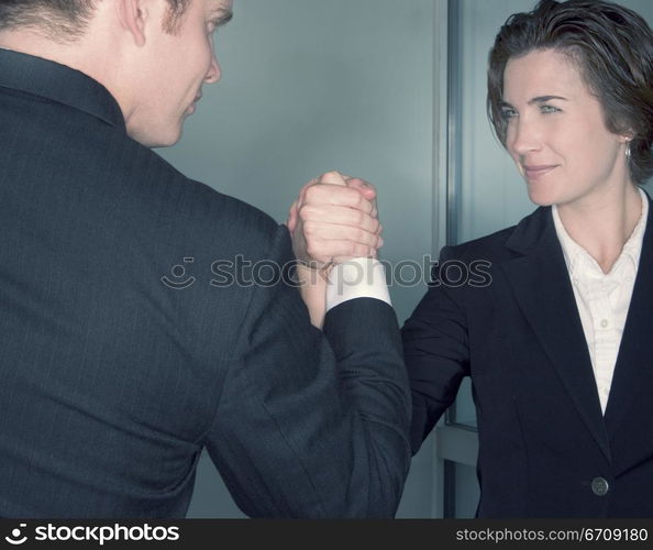 Business man and business woman grasp hands together