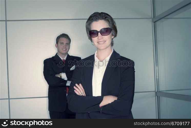 Business man and business woman pose as they stand next to each other