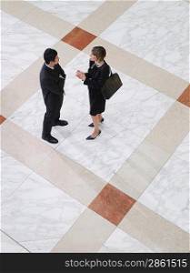 Business man and business woman talking elevated view