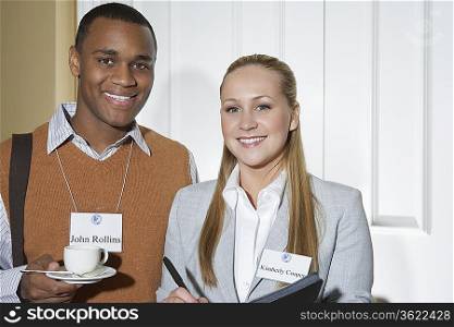 Business man and woman smiling in office, portrait