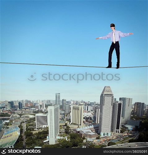 Business man balancing high over a cityscape
