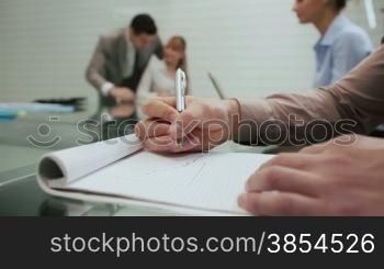 Business man drawing chart of negative loss during corporate presentation in meeting room, with colleague out of focus in background. Sequence, 5of20
