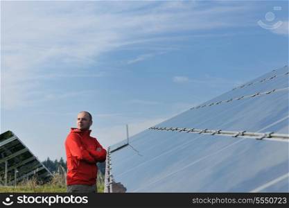 business man engineer using laptop at solar panels plant eco energy field in background