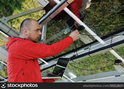 business man engineer using laptop at solar panels plant eco energy field in background