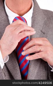 Business man fixing his tie, isolated over white