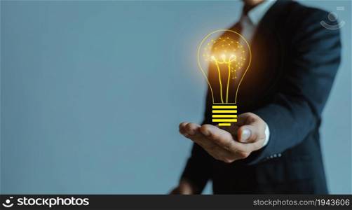 Business man hand holding light bulb with icon