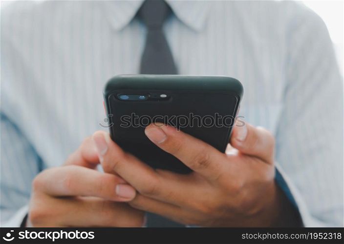 business man hand holding mobile phone.