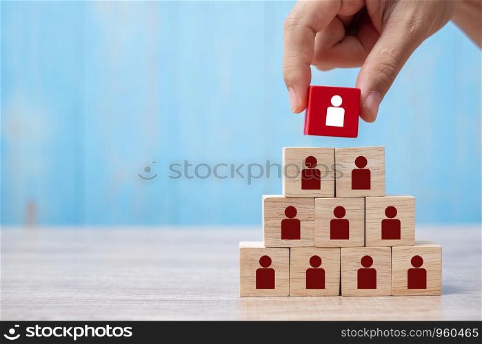 Business man hand placing or pulling Red wooden block with white person icon on the building. People, Business, Human resource management, Recruitment, Teamwork, strategy and leadership Concepts