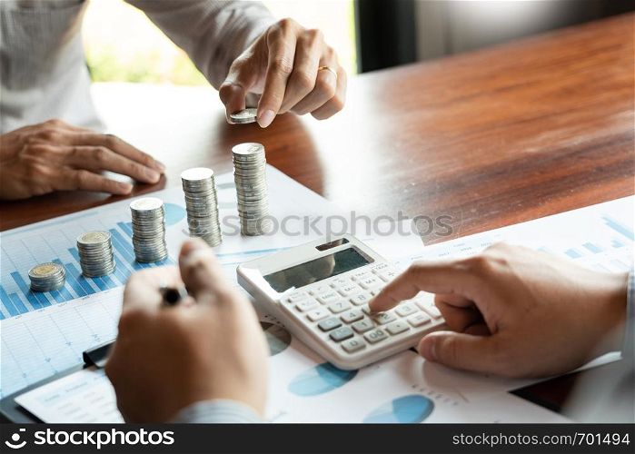 Business man hand putting coin stack for budget Saving money investment and financial accounting management or growing business concept.