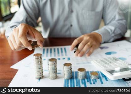 Business man hand putting coin stack for budget Saving money investment and financial accounting management or growing business concept