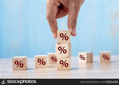 business man Hand putting wood cube block with percentage symbol icon. Interest rate, financial, ranking and mortgage rates concept